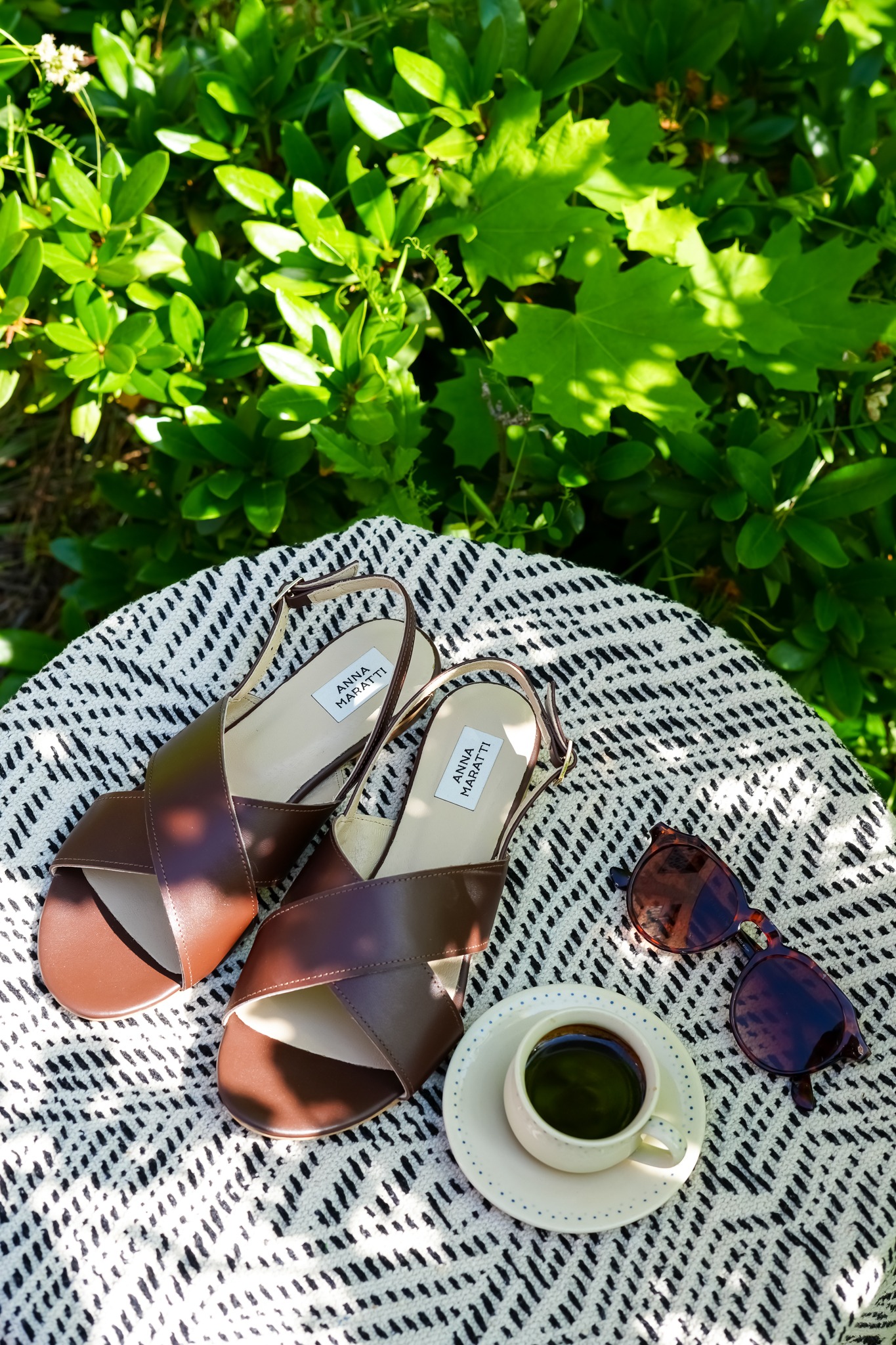 Tan leather Italy vacation sandals by Anna Maratti resting on sun-bleached Amalfi Coast steps, symbolising effortless European holiday style.